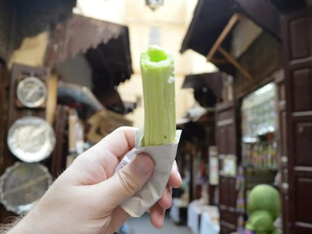 In this picture, there is a hand at the bottom and it is holding an object. In the background,...