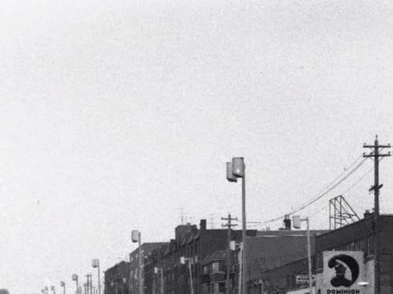 In the picture we can see black and white image of the buildings and near it we can see some poles...