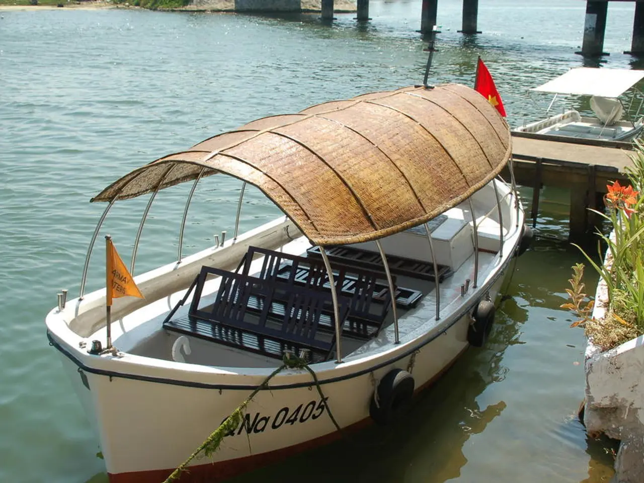 In this picture we can see a few boats in water. There is a flag. We can see some plants on the...