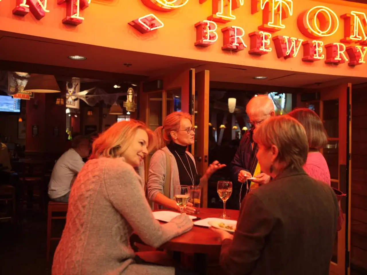 people are standing around the table. the person at the left is sitting. on the table there are...