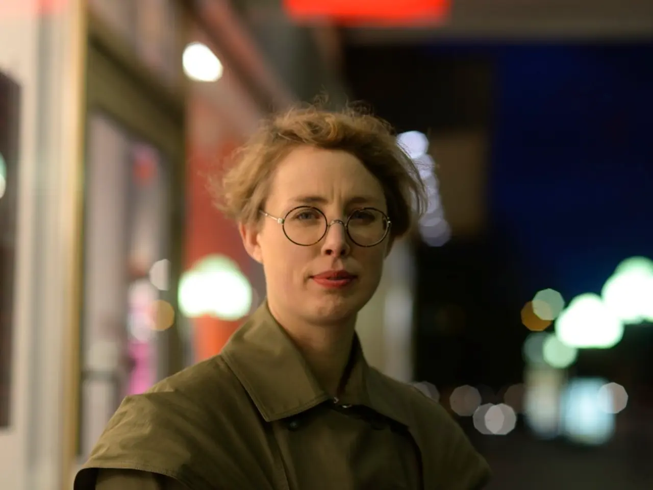 In this picture there is a woman wearing spectacles and there is a store in the left corner and...