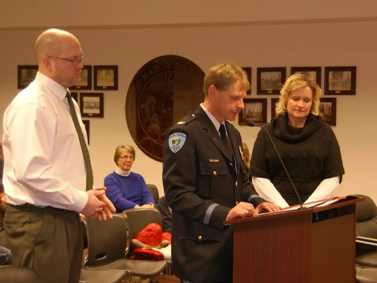 In this picture, we see two men and a woman are standing. The man in the middle of the picture is...