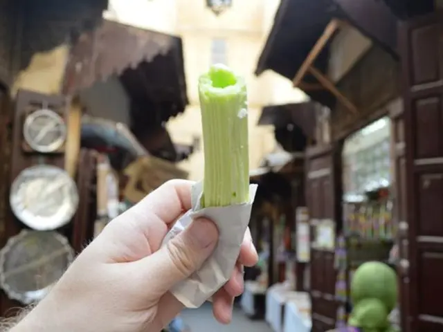 In this picture, there is a hand at the bottom and it is holding an object. In the background,...