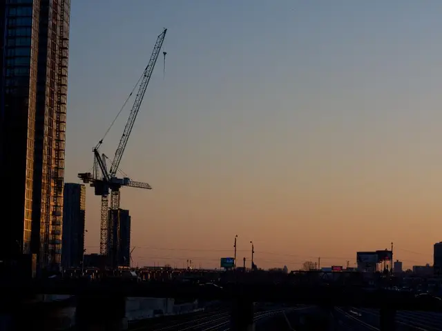 To the left side of the image there are buildings. There is a crane. There are electric poles and...