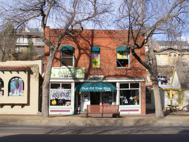 In the foreground of this image, there is a road. In the background, there are stoles, building,...