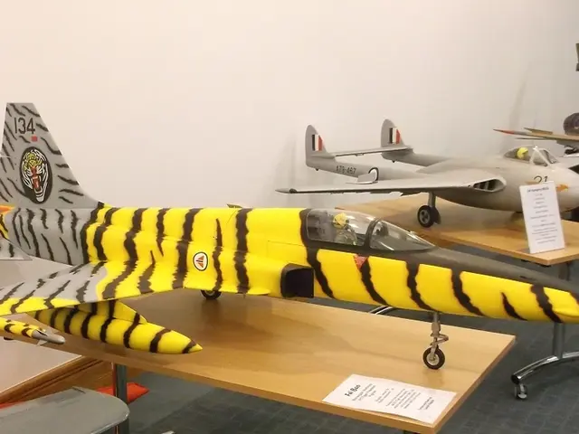 In this image there are a few models of airplanes are arranged on the tables with some labels on...