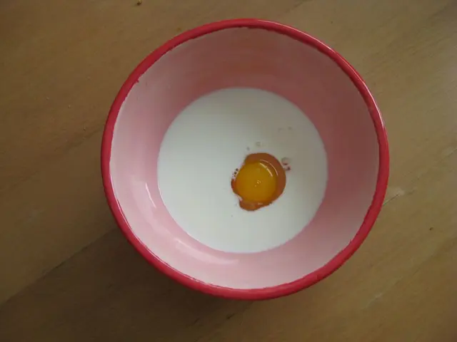 In this picture we can see a bowl, there is some milk and yolk present in this bowl, at the bottom...