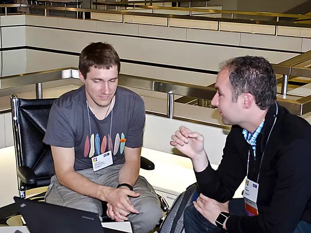 Here in this picture we can see two men sitting on chairs present on the floor and in front of them...