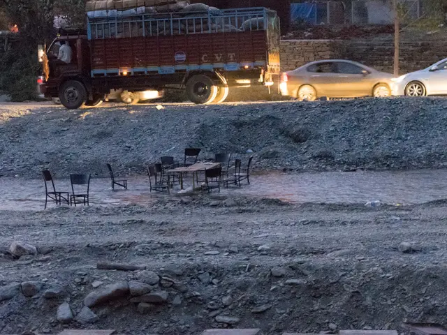 In this picture there is a lorry and some cars are moving on the road. In the front there are some...