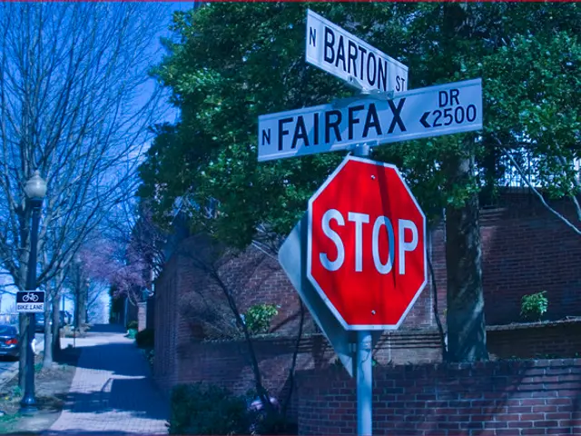 This picture shows few buildings and trees and we see few cars parked on the side of the road and...