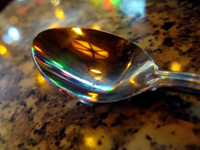 In this picture we can see a spoon and reflection of lights on a platform.